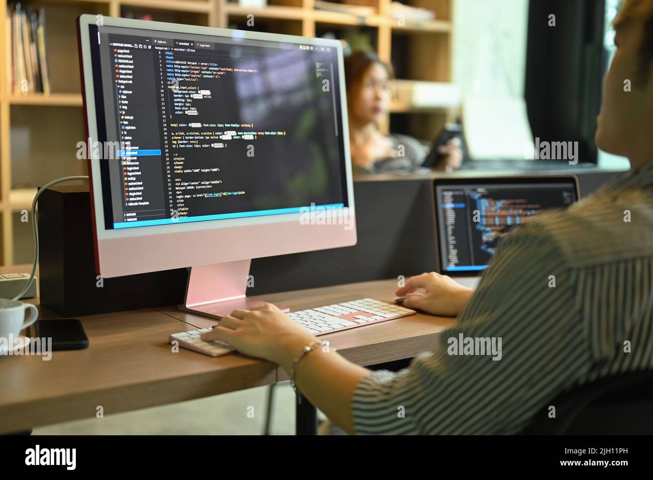 Vista ritagliata sviluppatore software maschile controllo errori nel codice di programmazione sullo schermo del computer Foto Stock