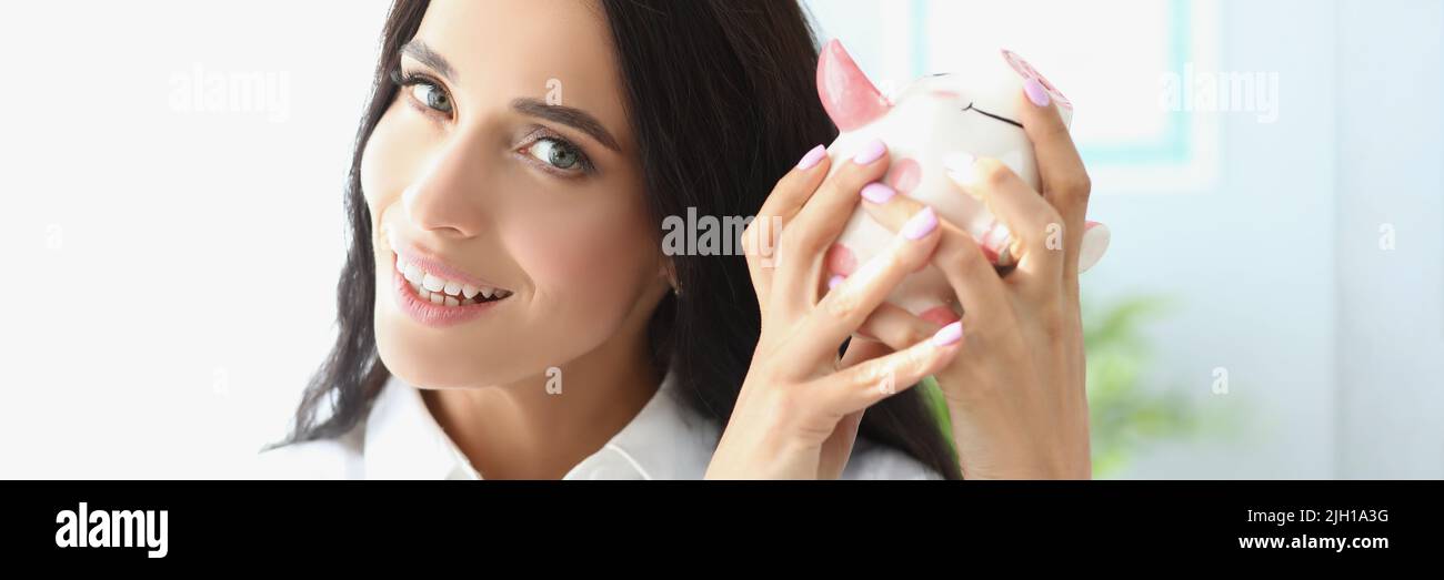 Donna persona scuotere piggybank nella speranza di ottenere soldi di esso Foto Stock