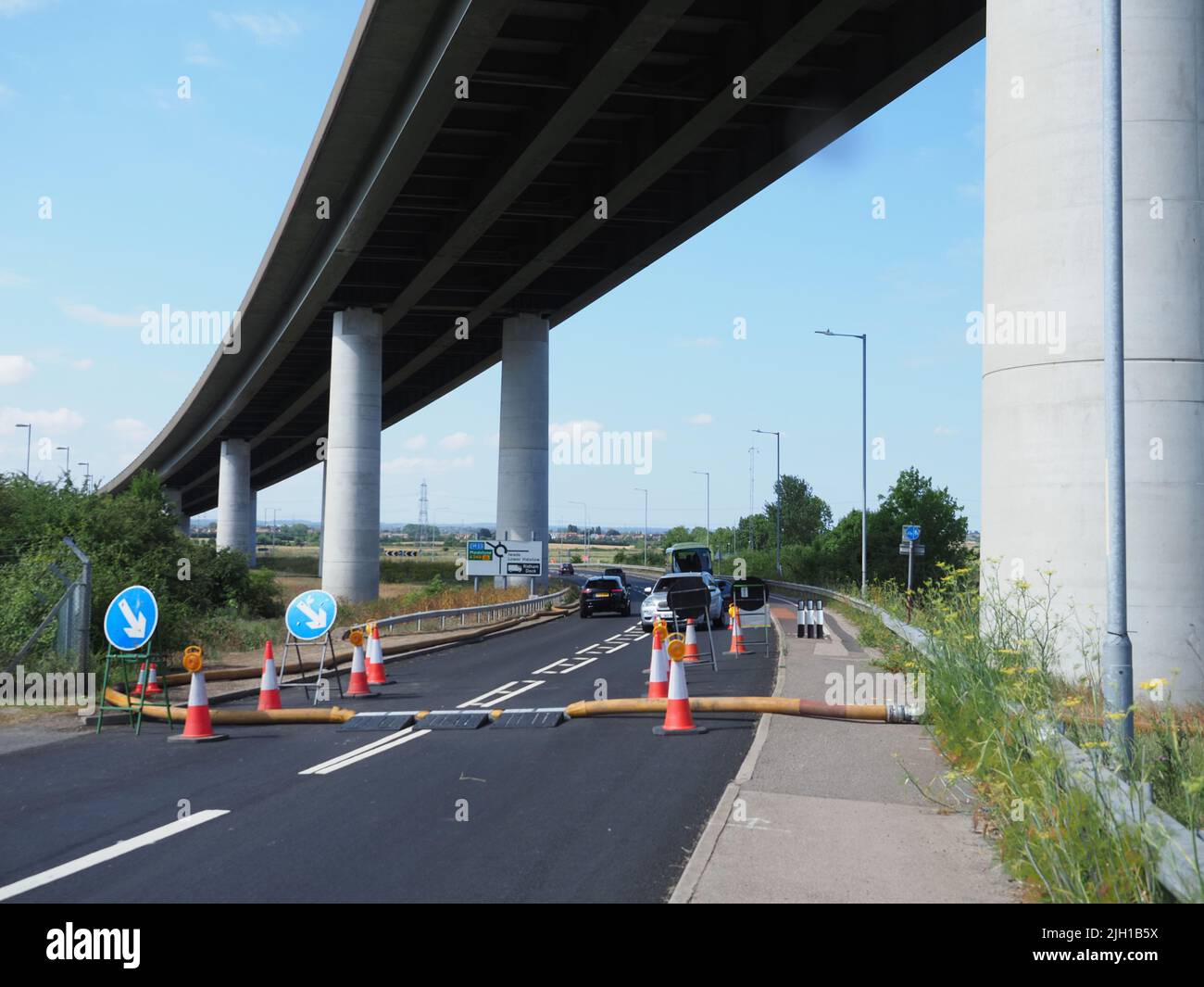 Iwade, Kent, Regno Unito. 14th luglio 2022. I problemi rimangono con l'approvvigionamento idrico dell'isola di Sheppey. Alcuni residenti sono ancora senza acqua quasi 3 giorni dopo che il principale tubo dell'acqua che alimenta l'isola scoppiò - anche se molti in Sheerness & Minster sono stati riconnessi a tarda notte. Un lungo (segnalato per essere 5km) tubo di fuoco è usato per pompare l'acqua vicino al Sheppey Crossing per contribuire a risolvere il problema (secondo Kent in linea) - ma anche questo ha mollato una perdita con acqua visto sparare in alto nell'aria (riparato dal momento di queste foto). Credit: James Bell/Alamy Live News Foto Stock