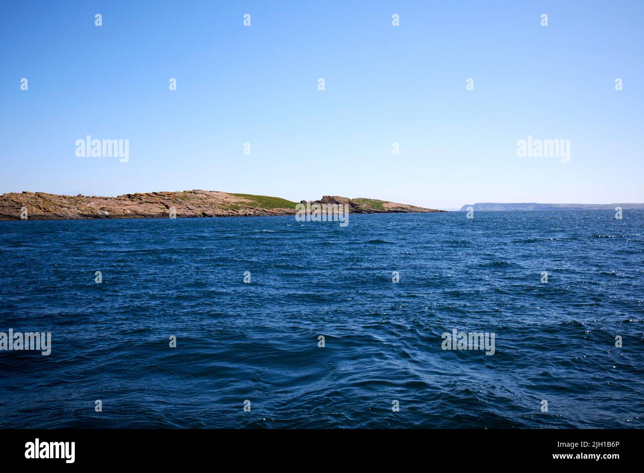 winkle isola grande skerry isola in mare al largo delle isole skerries con rathlin isola sullo sfondo costa nord dell'irlanda del nord su una mor estate Foto Stock