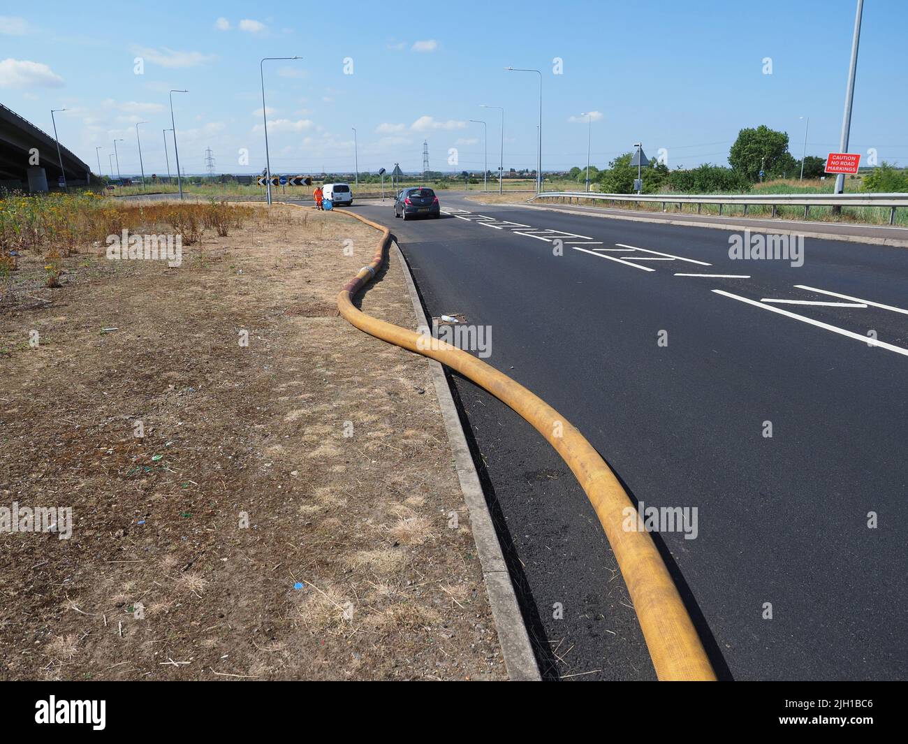 Iwade, Kent, Regno Unito. 14th luglio 2022. I problemi rimangono con l'approvvigionamento idrico dell'isola di Sheppey. Alcuni residenti sono ancora senza acqua quasi 3 giorni dopo che il principale tubo dell'acqua che alimenta l'isola scoppiò - anche se molti in Sheerness & Minster sono stati riconnessi a tarda notte. Un lungo (segnalato per essere 5km) tubo di fuoco è usato per pompare l'acqua vicino al Sheppey Crossing per contribuire a risolvere il problema (secondo Kent in linea) - ma anche questo ha mollato una perdita con acqua visto sparare in alto nell'aria (riparato dal momento di queste foto). Credit: James Bell/Alamy Live News Foto Stock