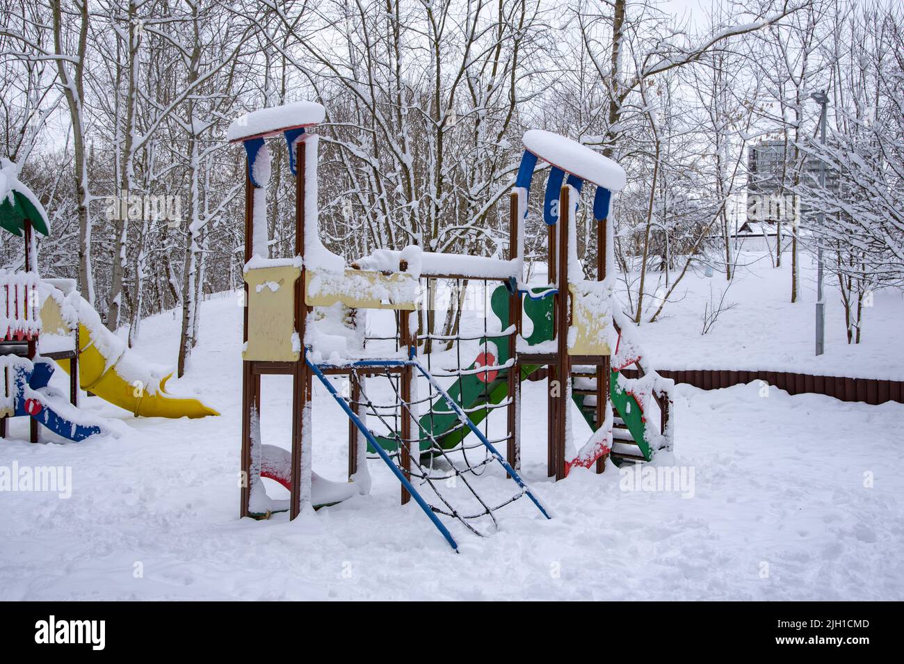Un parco giochi vuoto per bambini nella neve. Foto Stock
