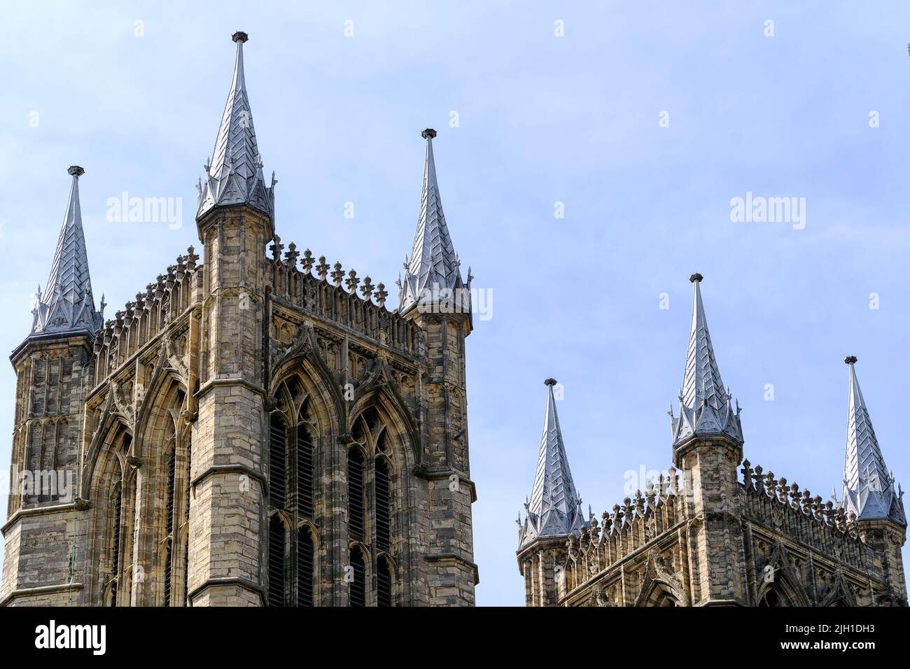 Le cime di due delle tre torri che dominano la Cattedrale di Lincoln e sono delineate vividamente contro un cielo azzurro chiaro. Foto Stock
