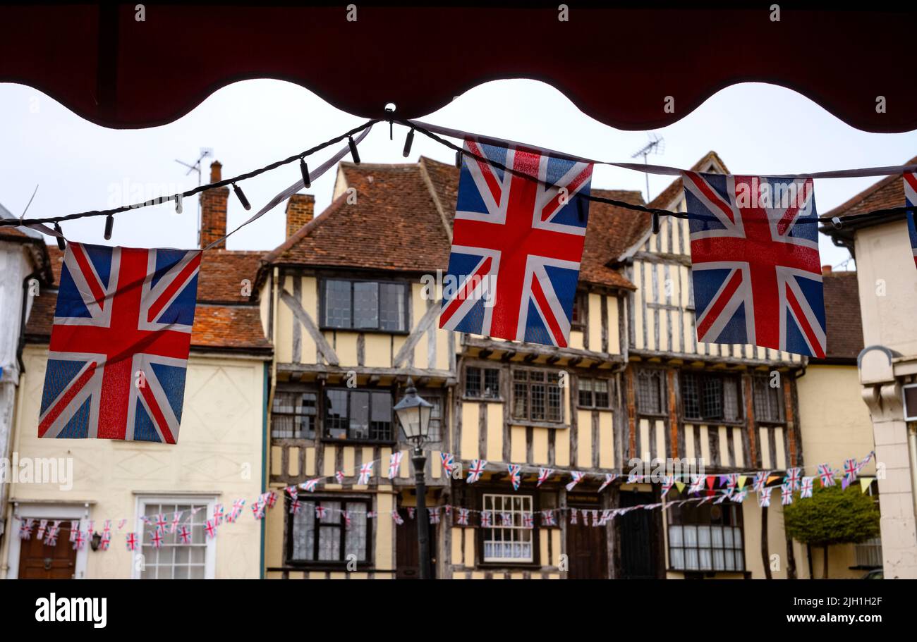 Thaxted Essex England Union Jack Flags and old Buildings Luglio 2022 Union Jack bandiere flutter di fronte a Dick Turpins House e il 14th secolo Guildhall Foto Stock