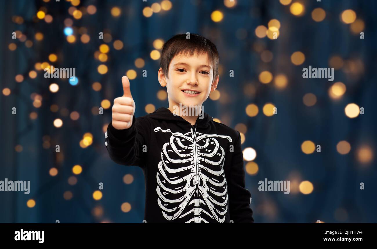 ragazzo in costume scheletro halloween mostra i pollici in su Foto Stock