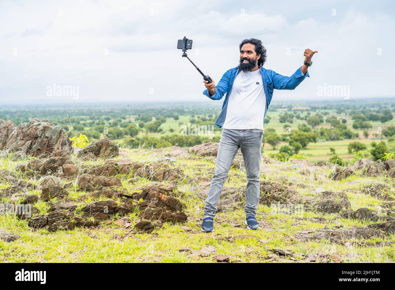 full shot di vlogger di viaggio in cima alla montagna registrazione video su cellulare di soical media - concetto di influencer e creatore di contenuti Foto Stock