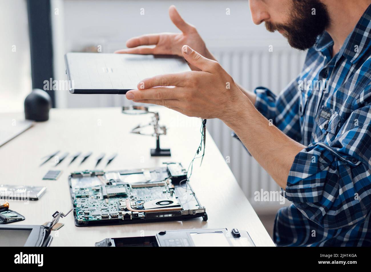 Smontaggio del computer portatile presso il negozio di riparazione elettronica Foto Stock