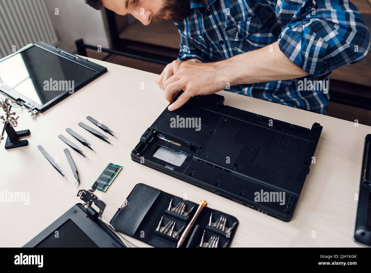Smontaggio del computer portatile con un cacciavite durante la riparazione Foto Stock