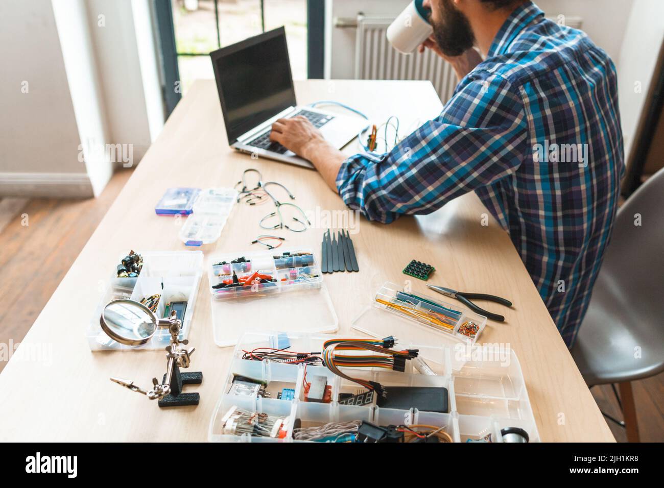 Programmatore impegnato a bere caffè sul posto di lavoro Foto Stock