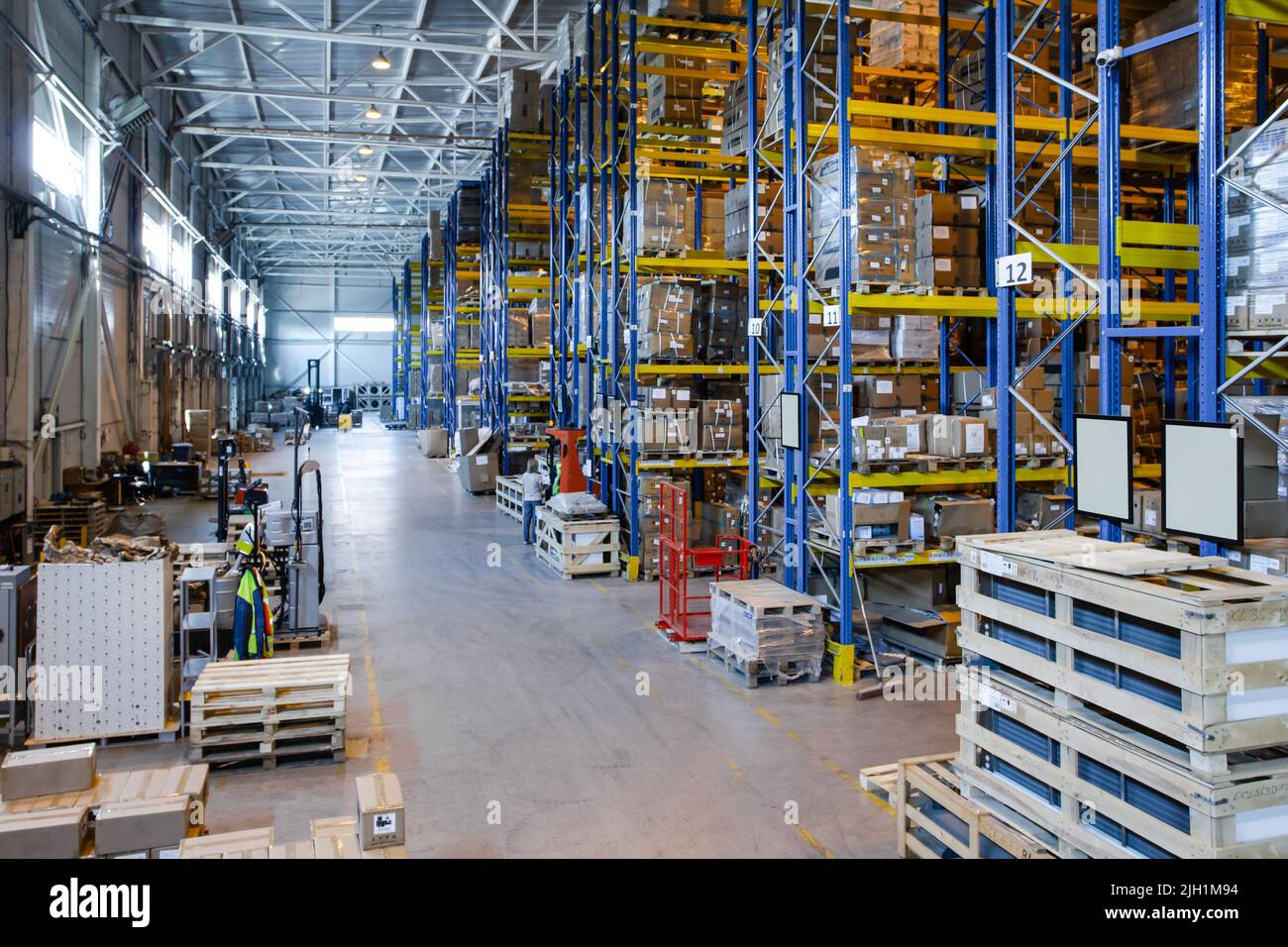 Interno di un magazzino moderno di negozi al dettaglio con transpallet vicino ai ripiani Foto Stock