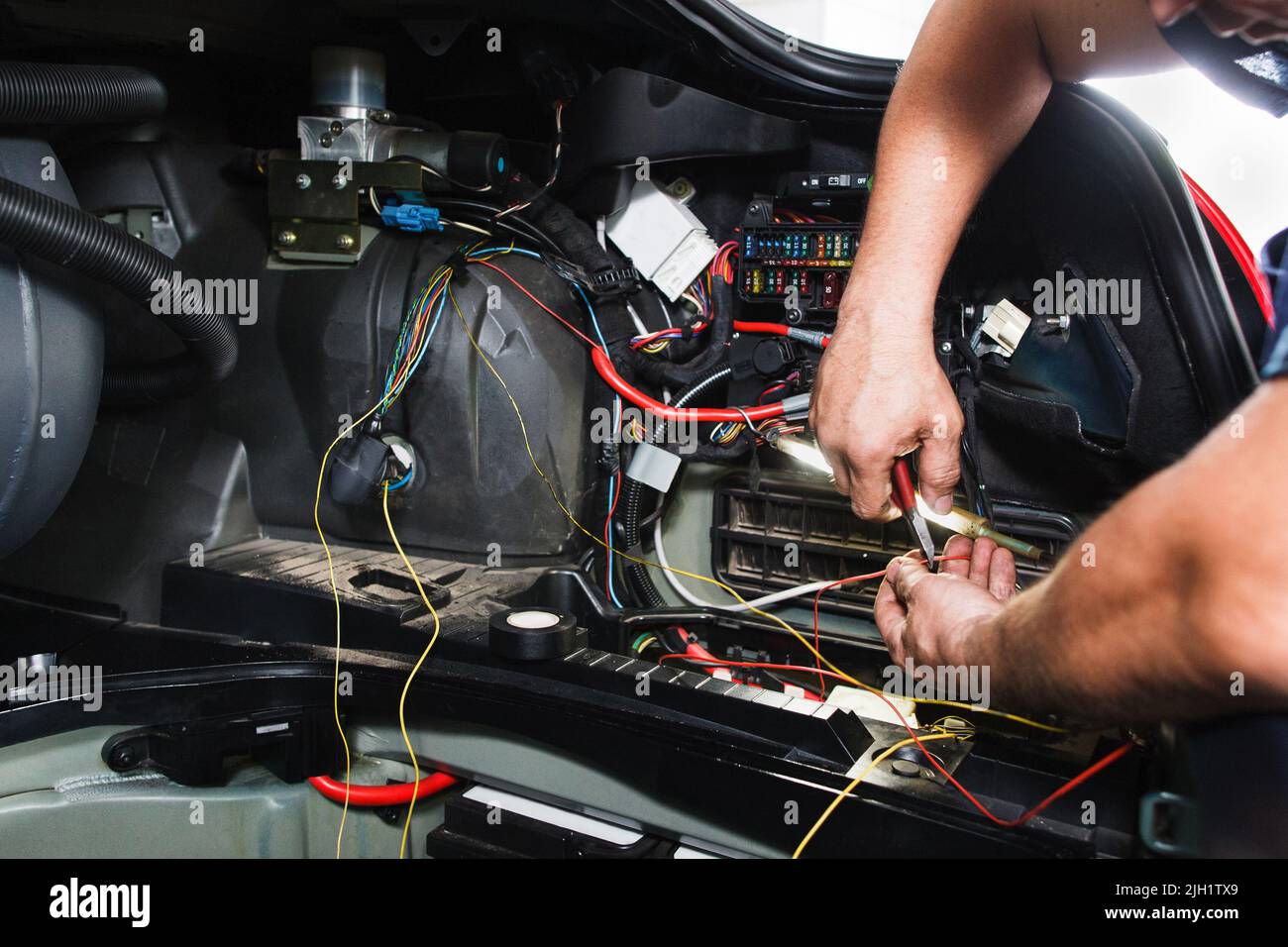L'elettricista lavora con il blocco elettrico in auto Foto Stock