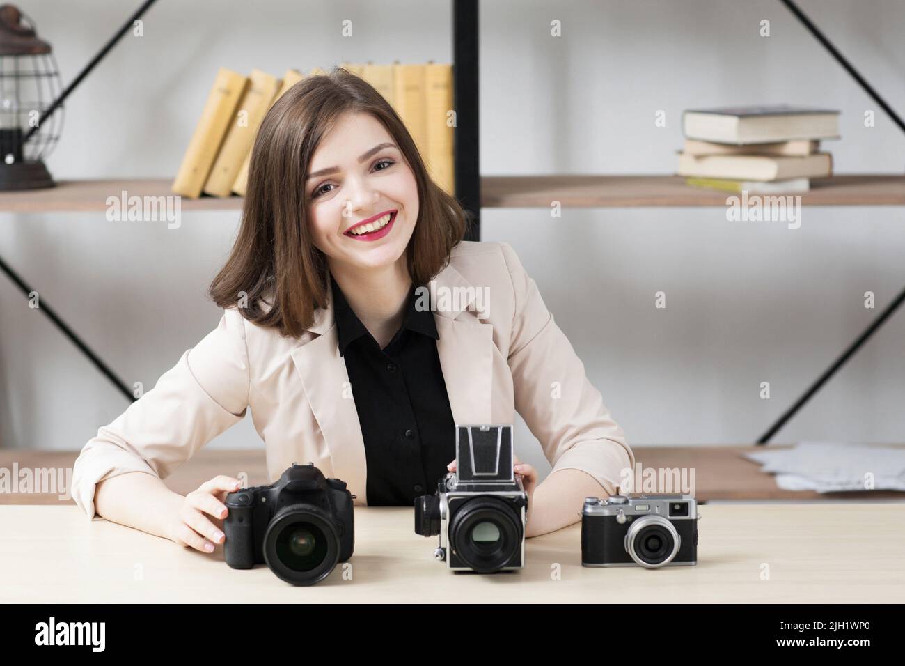 Donna sorridente con tre fotocamere Foto Stock