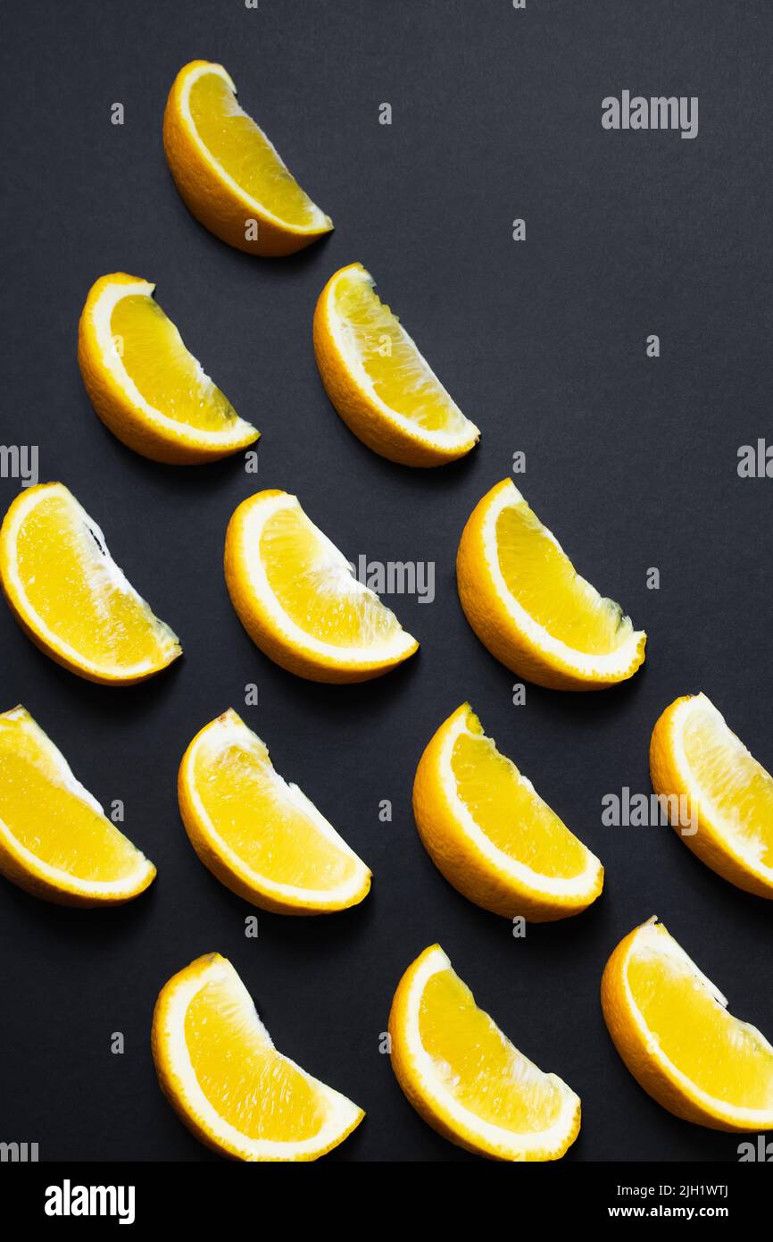 Piatto con pezzi di arance su sfondo nero Foto Stock
