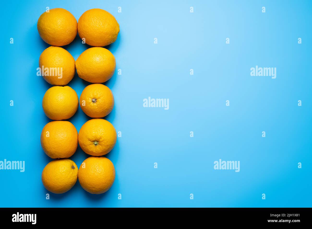 Piatto di arance organiche su sfondo blu Foto Stock