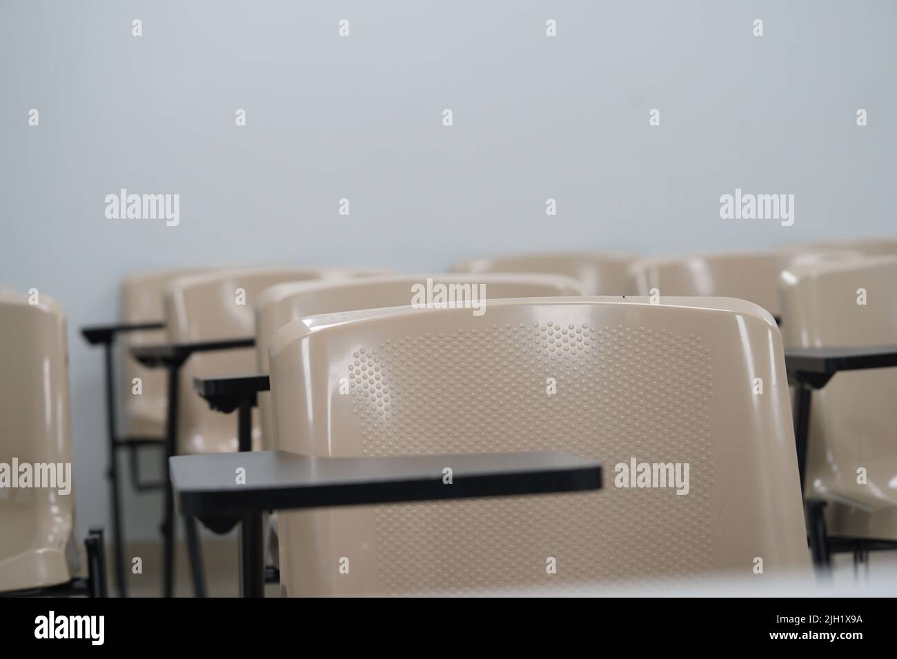 Lezione vuota all'università o alla scuola con sedie e tavolino e grande asse in background. Le sedie sono disposte in file. Foto Stock