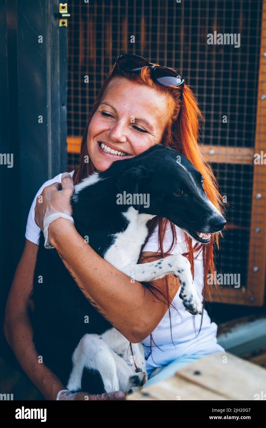 Un cane senza tetto salvato si sente sicuro nelle mani di un volontario. I volontari aiutano gli animali domestici ucraini. Aiuto agli animali. Uzhhorod, Ucraina Foto Stock