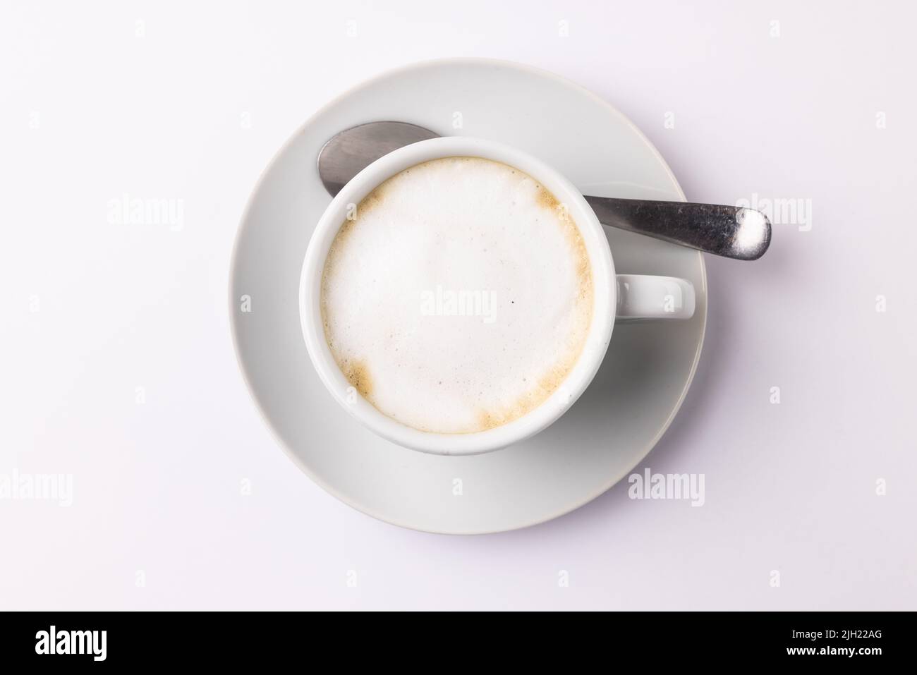 Immagine di una tazza di caffè bianca con latte su sfondo bianco Foto Stock