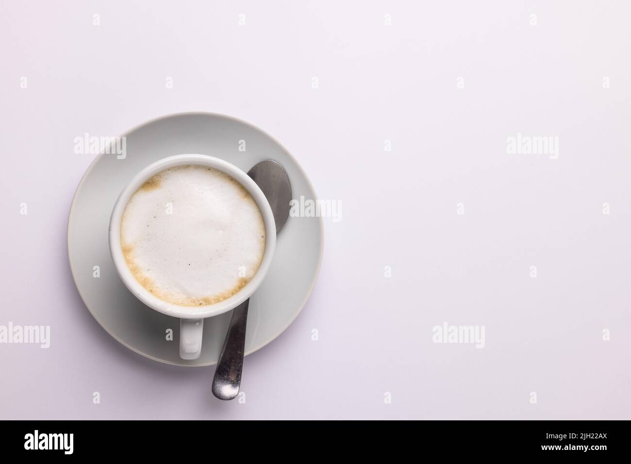 Immagine di una tazza di caffè bianca con latte su sfondo bianco Foto Stock