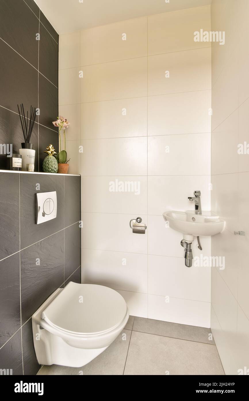 La parete nera appesa wc in interni minimalisti del bagno con cabina doccia Foto Stock