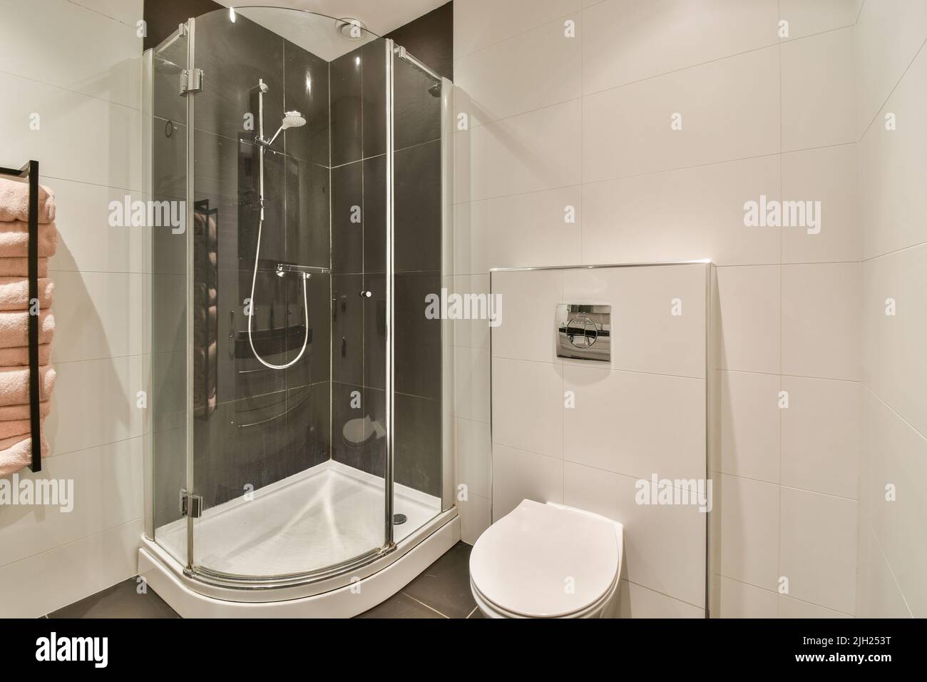 La parete nera appesa wc in interni minimalisti del bagno con cabina doccia Foto Stock