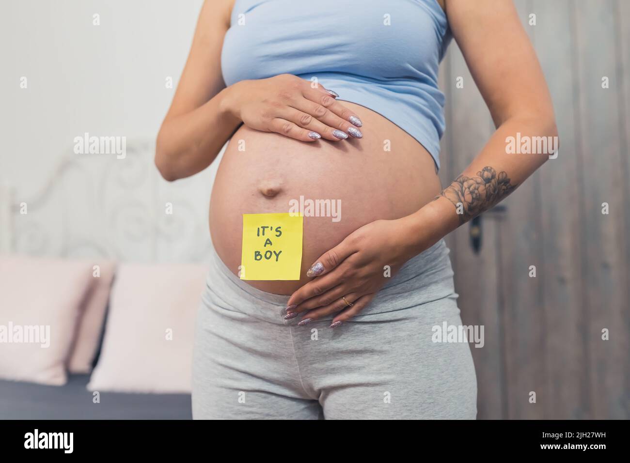 donna incinta con una nota appiccicosa che dice ragazzo sul ventre, primo piano sesso rivelare concetto. Foto di alta qualità Foto Stock