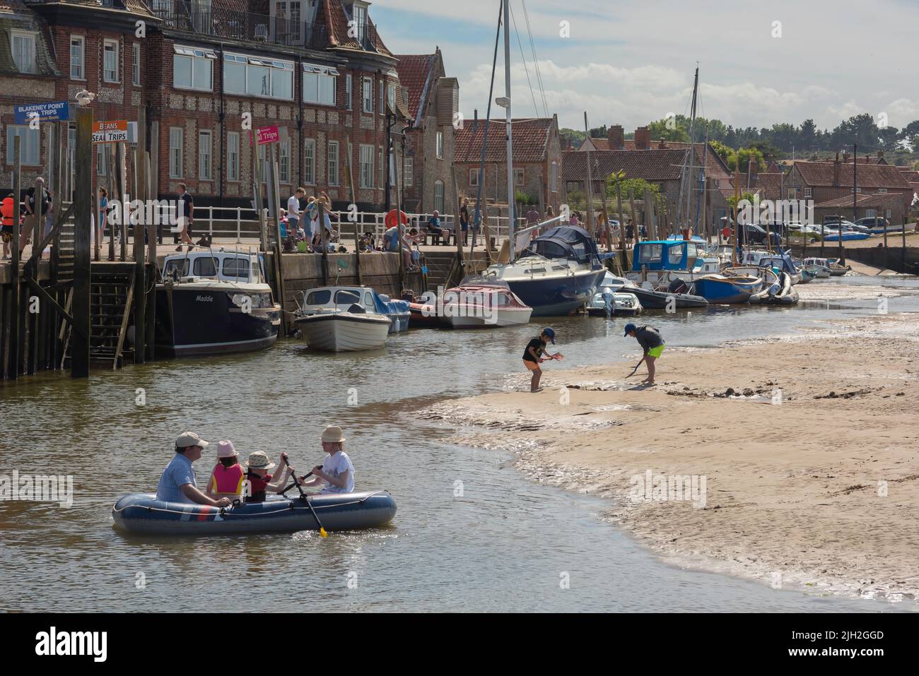 Famiglia estate Regno Unito, vista in estate dei bambini godendo di un pomeriggio estivo nel porto di Blakeney, una tradizionale città vacanze sulla costa nord del Norfolk Regno Unito Foto Stock