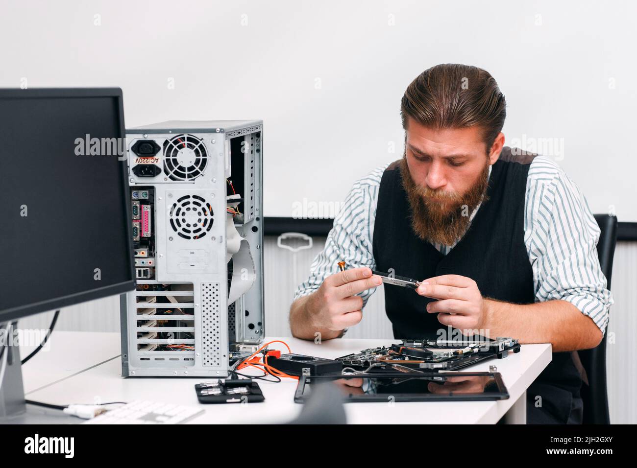 Il personale addetto al riparazione esamina la parte interna del computer Foto Stock