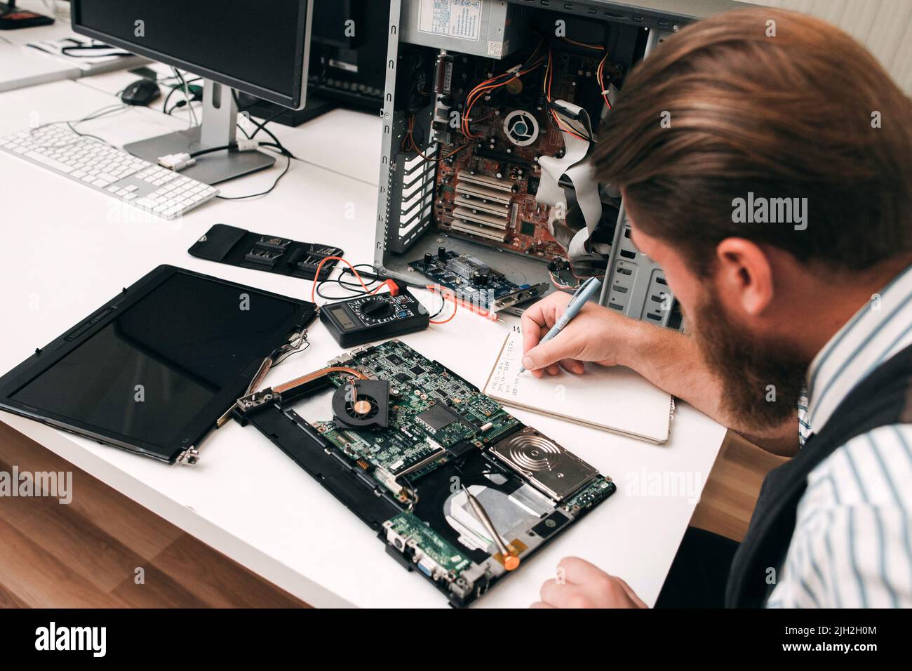 Programmatore bearded che ispeziona la scheda madre del computer Foto Stock