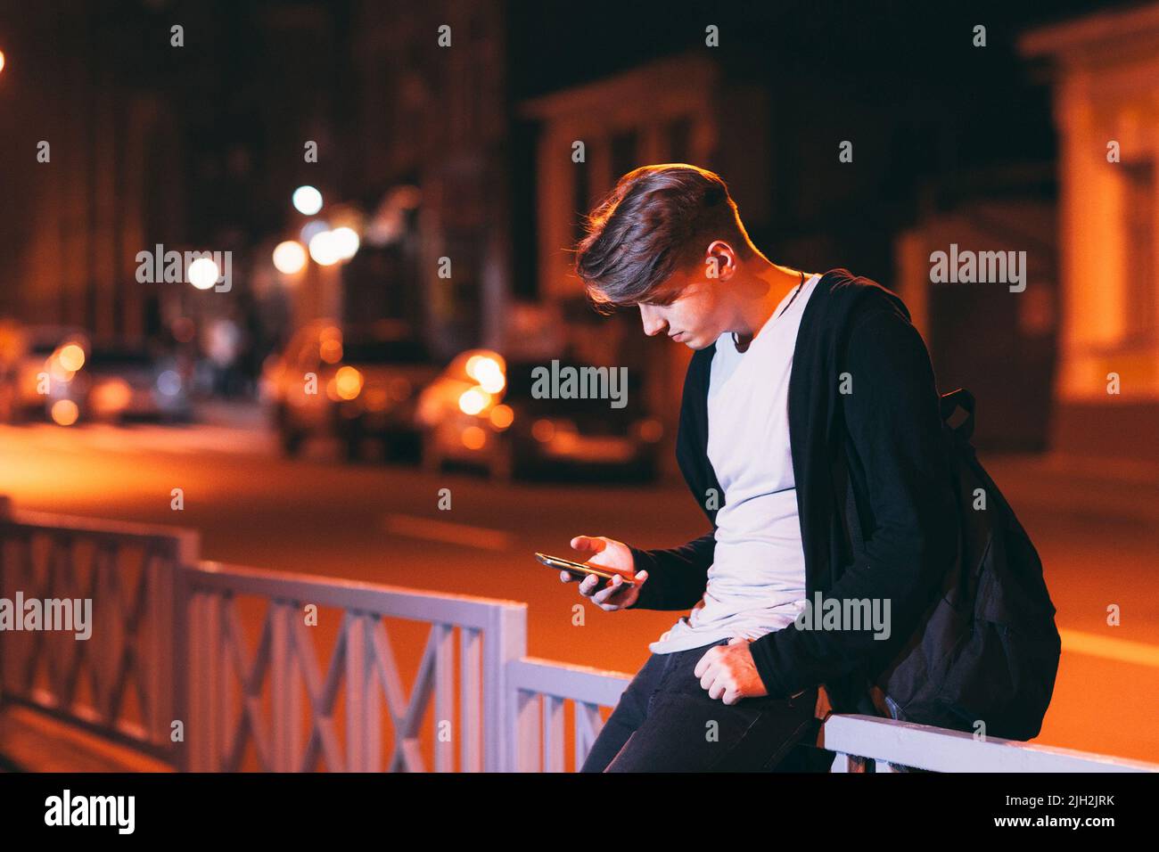 Giovane uomo che legge smartphone fuori Foto Stock