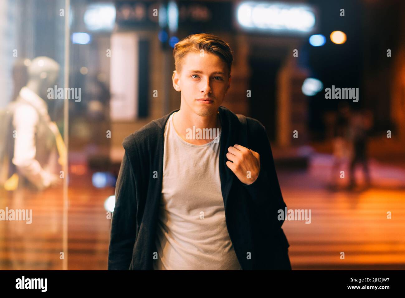 L'uomo attraente cammina per le strade di notte Foto Stock