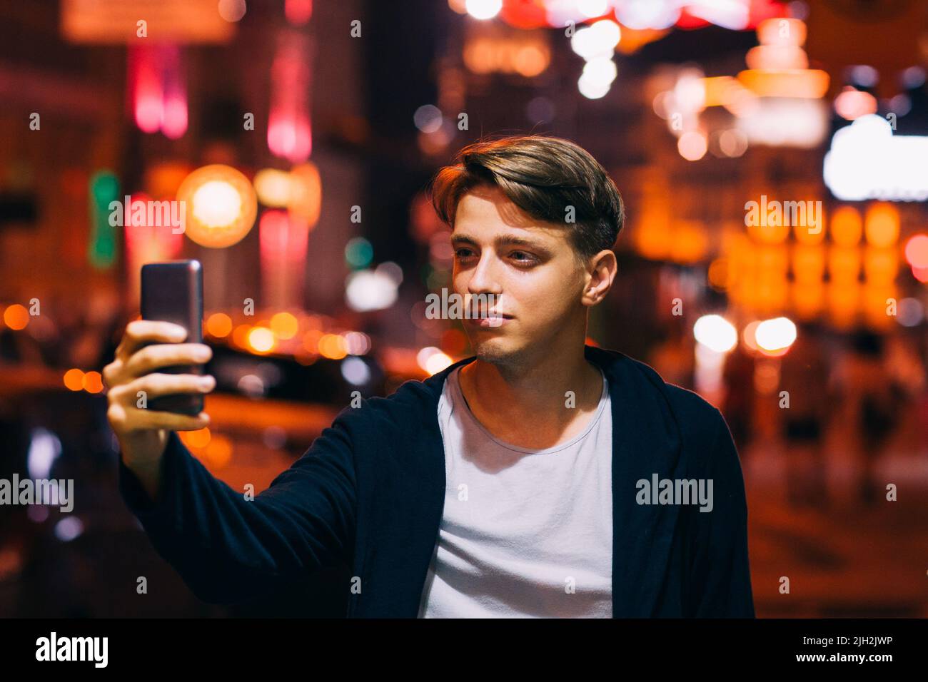 Giovane uomo prendere selfie su smartphone in città Foto Stock