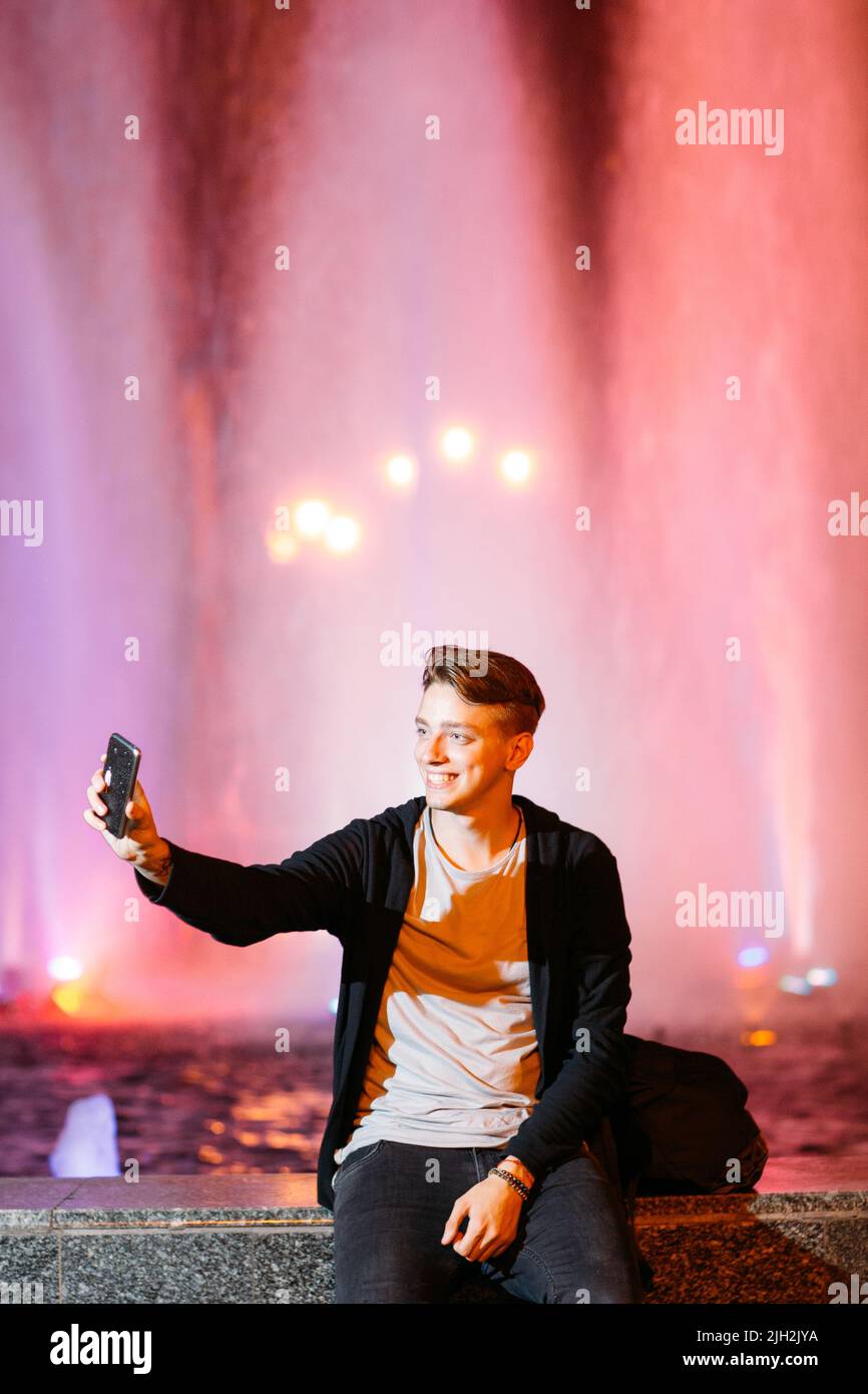 Giovane uomo prendere selfie su smartphone in città Foto Stock
