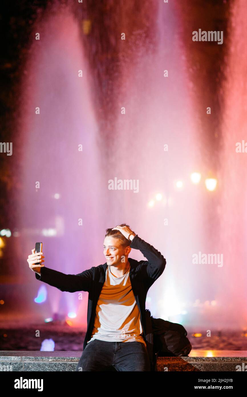 Giovane uomo prendere selfie su smartphone in città Foto Stock