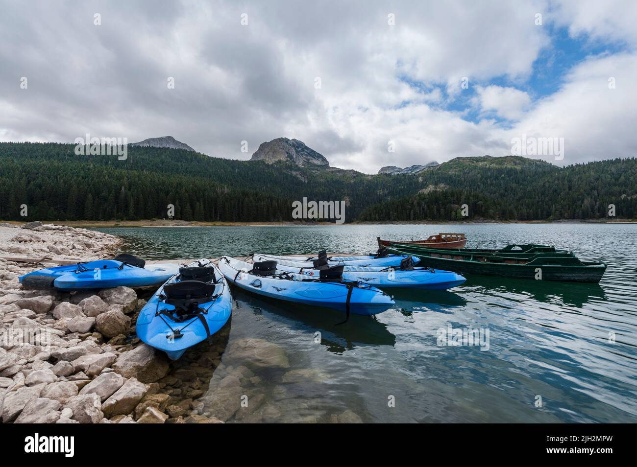 Alcune canoe blu in attesa di turisti sul bordo del Lago Nero nel Parco Nazionale Durmitor, comune di Žabljak, Montenegro settentrionale Foto Stock