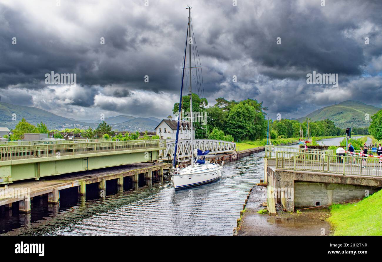 FORT WILLIAM CALEDONIAN CANAL NEPTUNES SCALA UNO YACHT CHE PASSA I DUE PONTI DI OSCILLAZIONE UNA STRADA E UNA FERROVIA Foto Stock