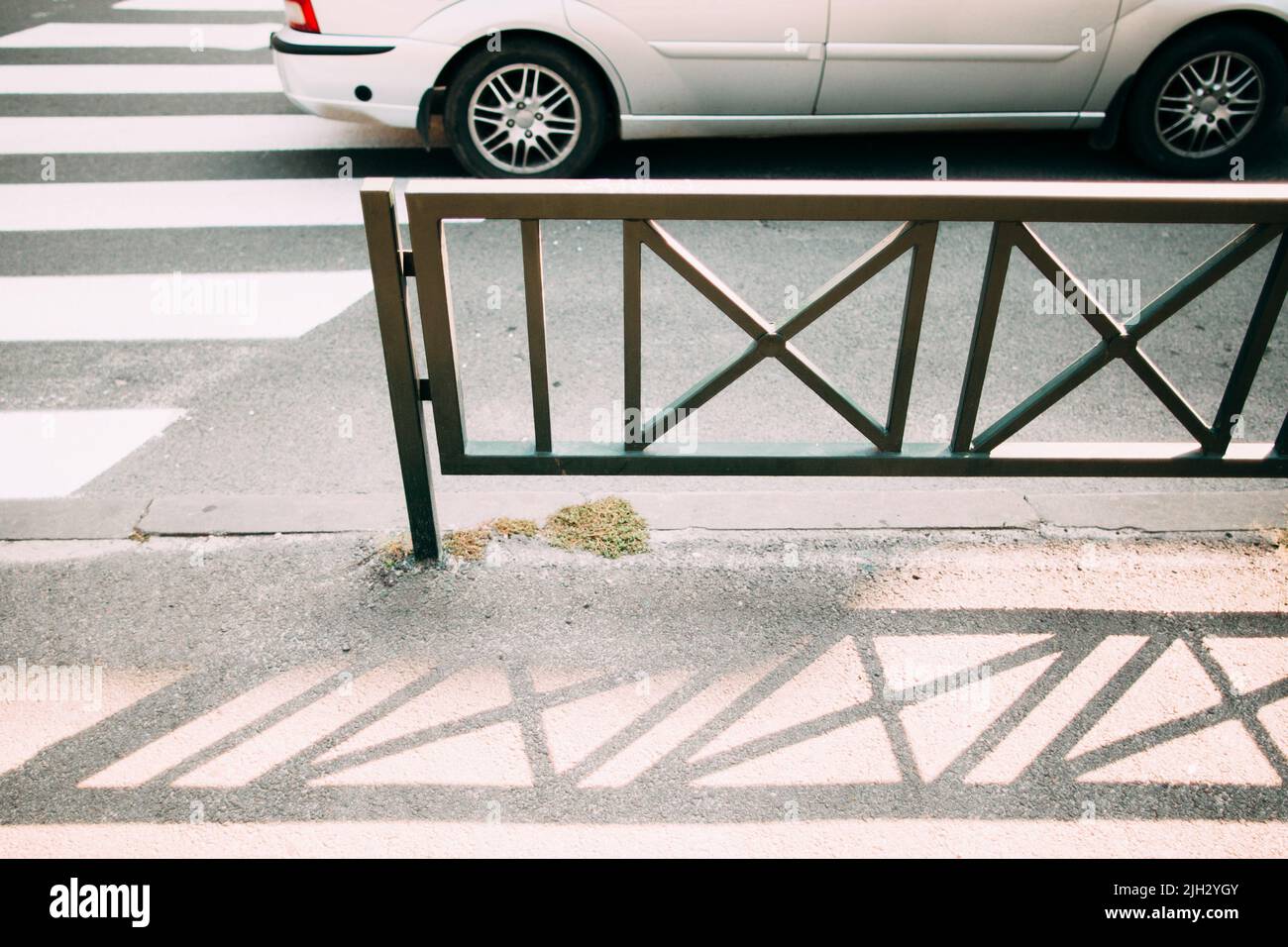 Recinzione in acciaio vicino zebra pedonale, sfondo auto Foto Stock