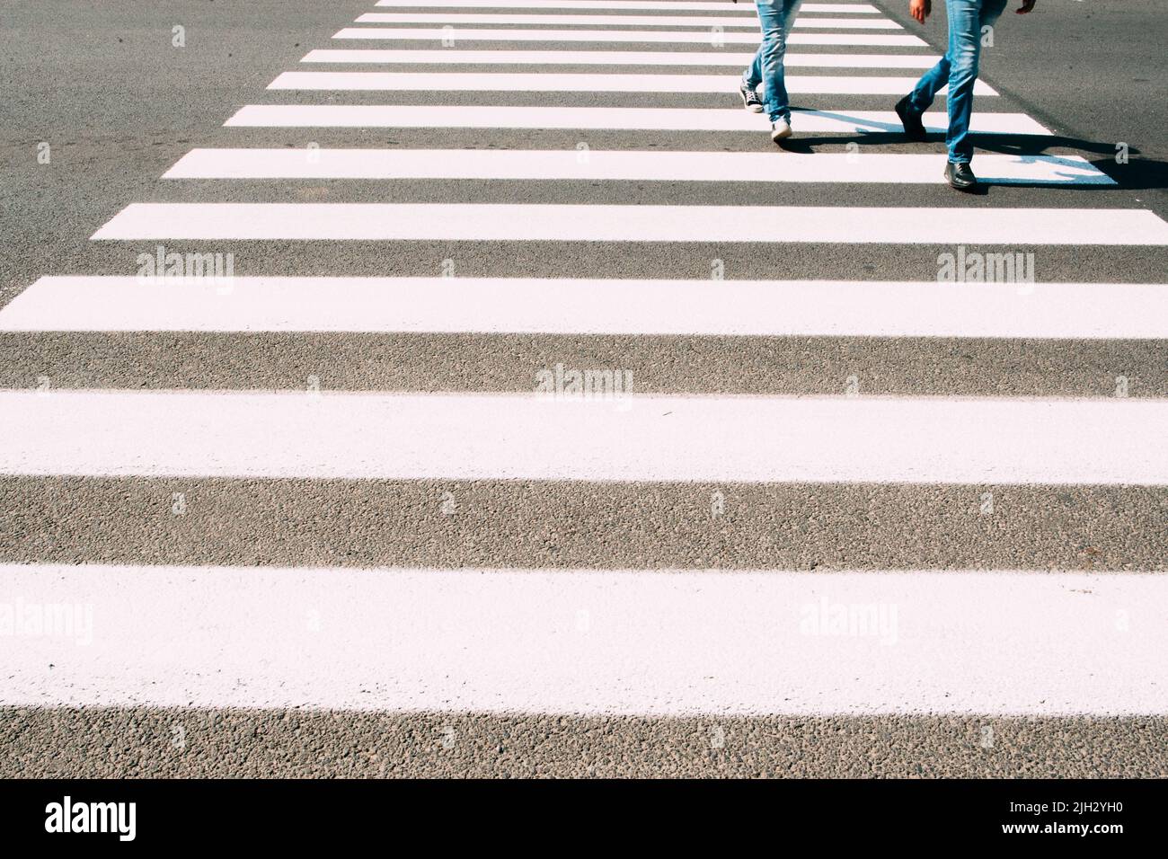 Uomini che corrono su zebra pedonale Foto Stock
