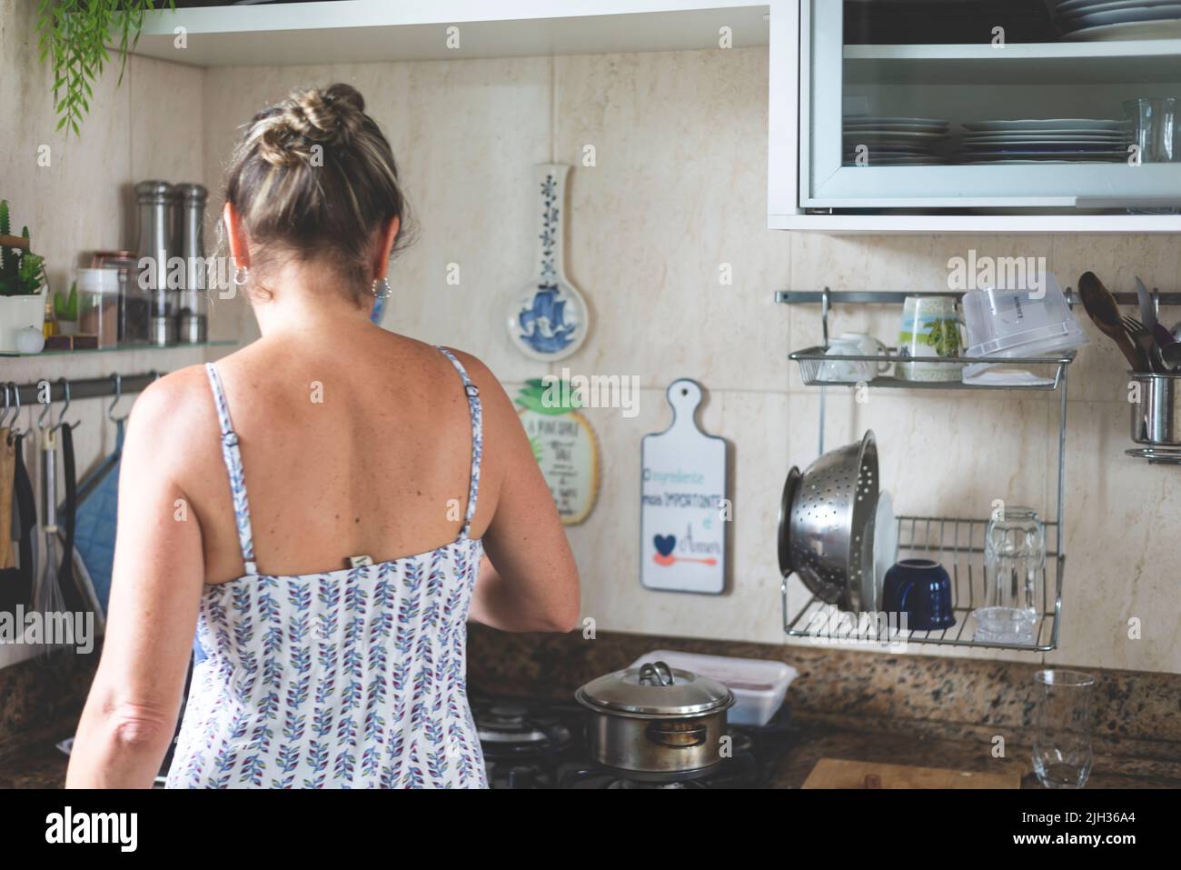 Giovane donna dalla parte posteriore che fa il cibo in cucina. Foto Stock