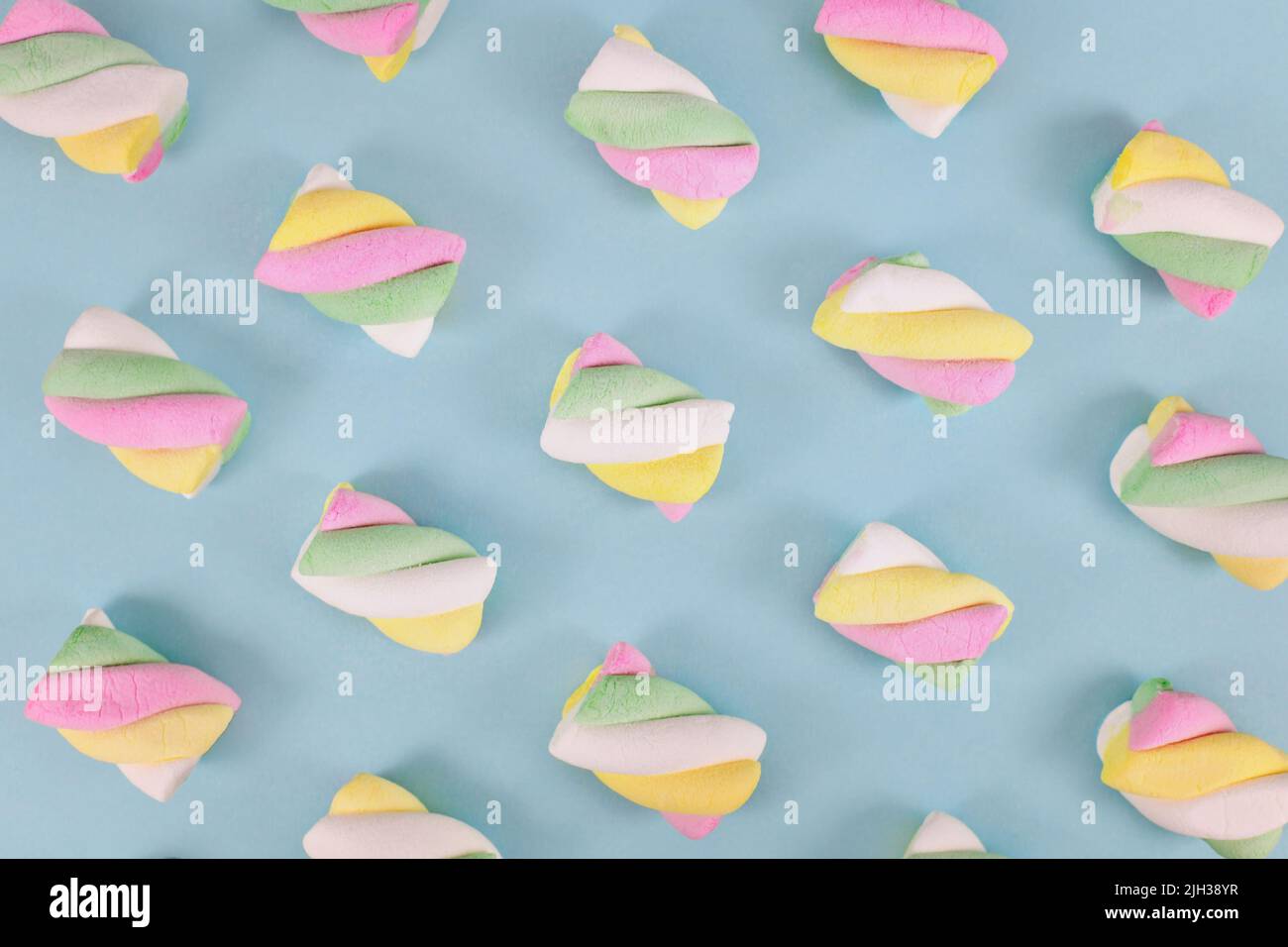 Caramelle multicolore marshmallow su sfondo blu teal Foto Stock