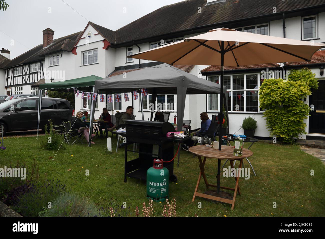 Persone sotto gazebo che hanno barbecue a Street Party celebrare Queen Elizabeth II Platinum Jubilee Surrey Inghilterra Foto Stock