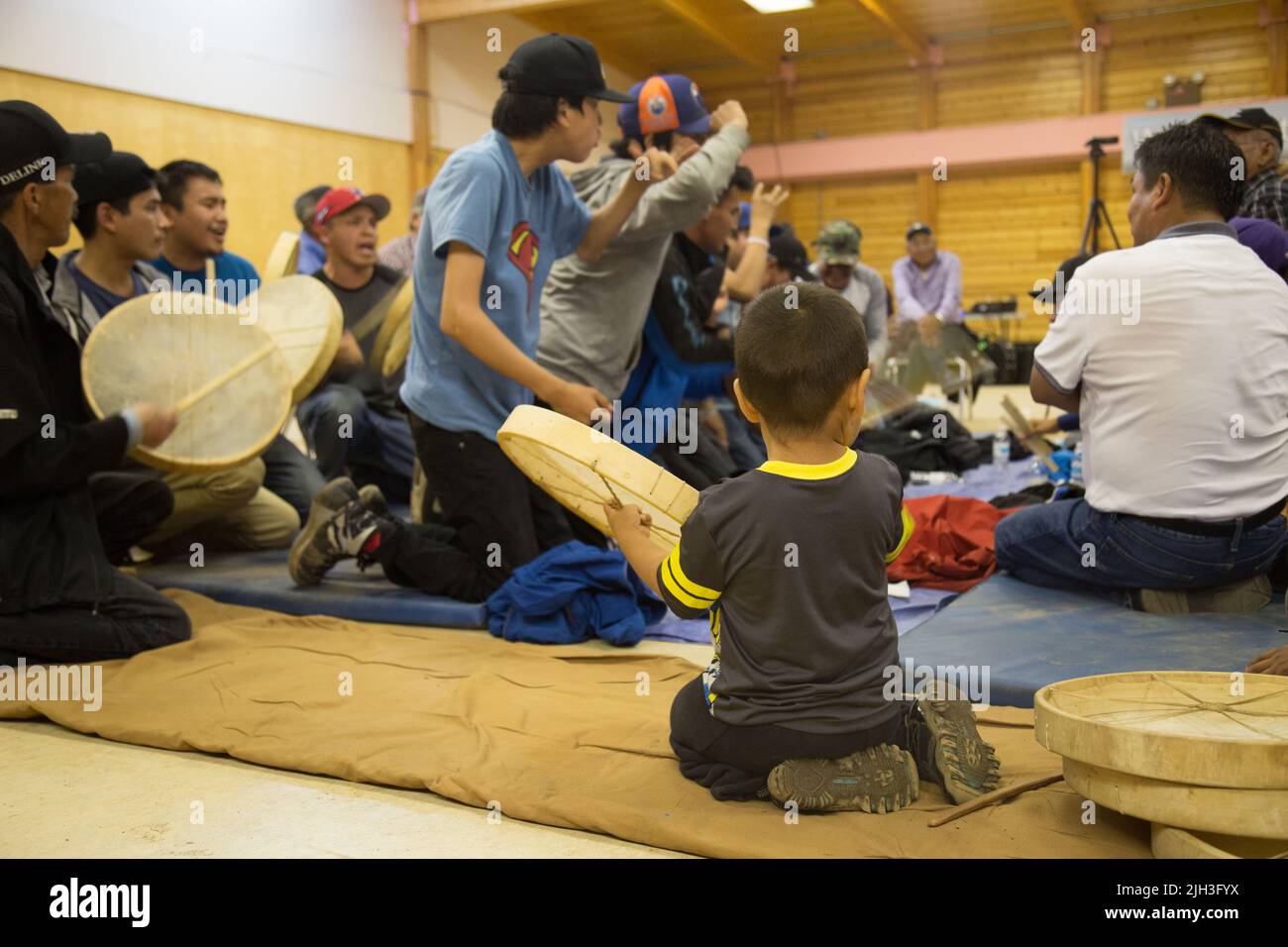 Il giovane ragazzo di Dene gioca un tamburo ai giochi di mano della comunità, nella comunità indigena del nord di Deline, territori del nord-ovest, Canada Foto Stock