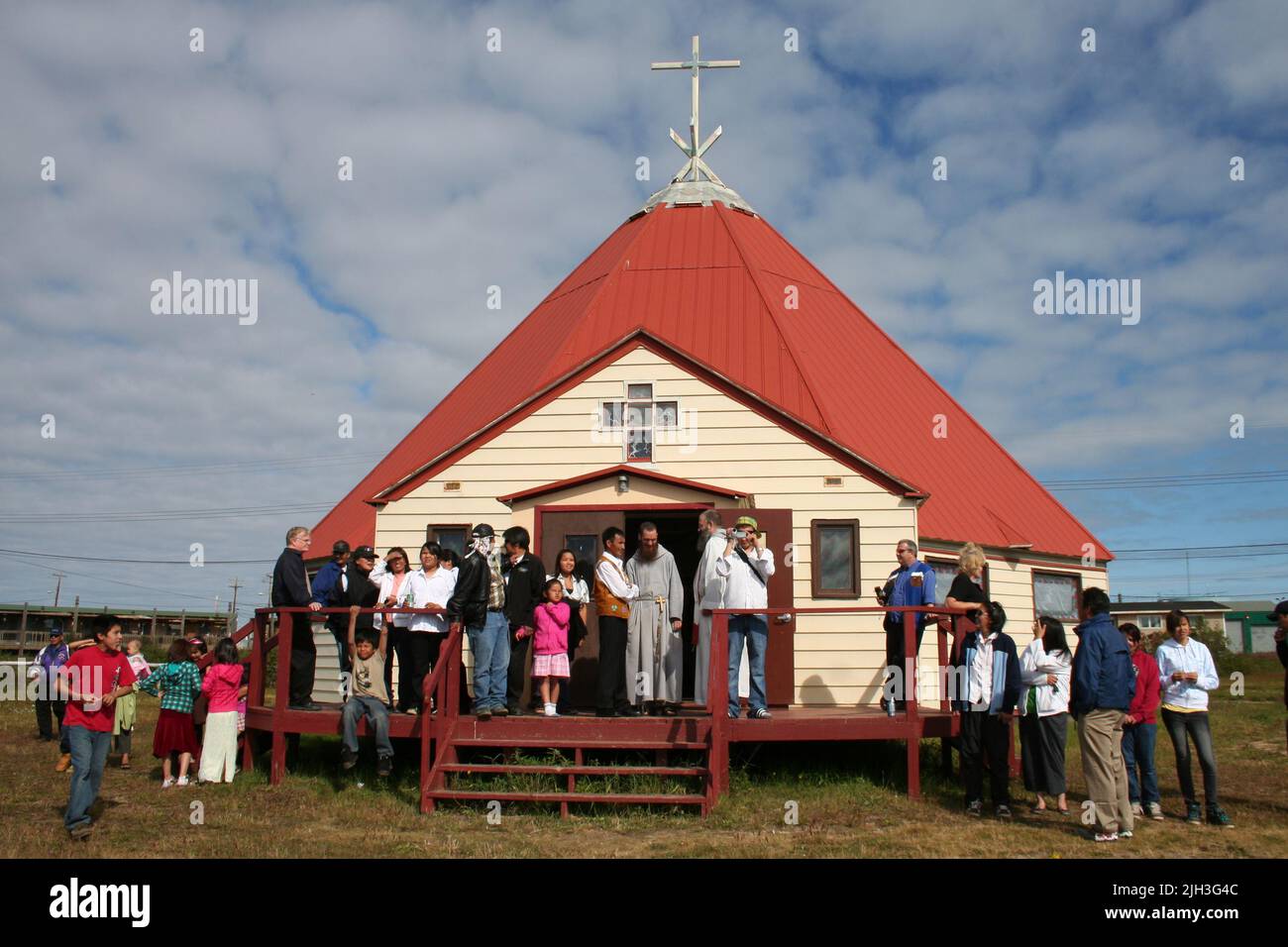La gente si radunò fuori dalla Chiesa Cattolica Romana di Santa Teresa del Bambino Gesù nella comunità indigena di Deline, territori del Nord-Ovest Foto Stock