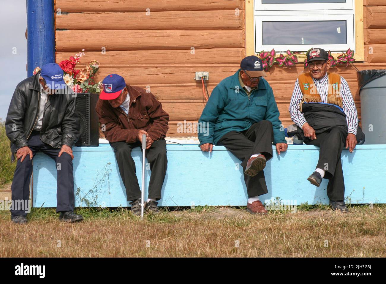 Gli anziani indigeni di Dene seduti fuori dalla casa del Profeta Ayah in un giorno d'estate, nella comunità settentrionale di Deline, territori nordoccidentali, Canada. Foto Stock