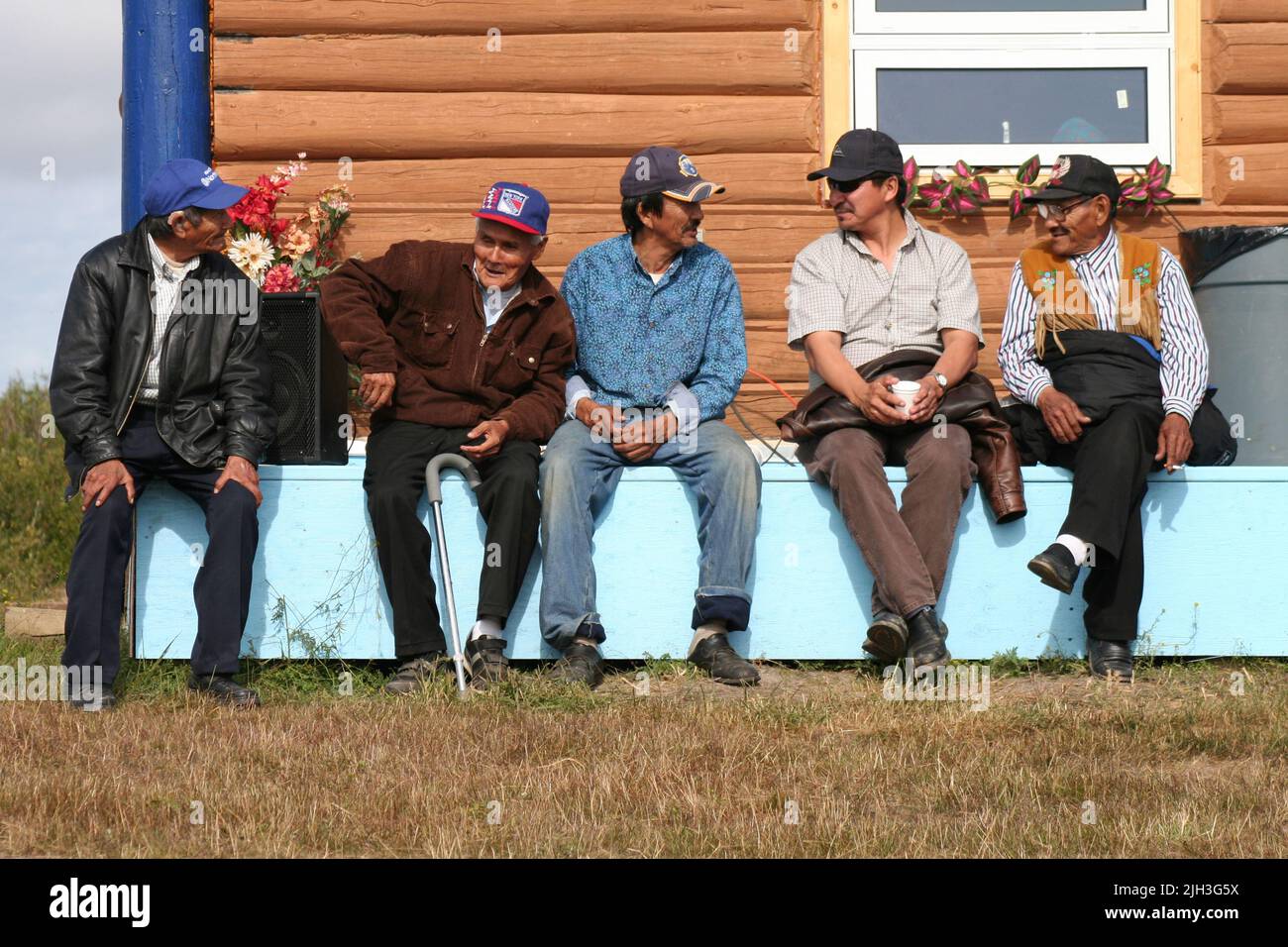 Gli anziani indigeni di Dene seduti fuori dalla casa del Profeta Ayah in un giorno d'estate, nella comunità settentrionale di Deline, territori nordoccidentali, Canada. Foto Stock