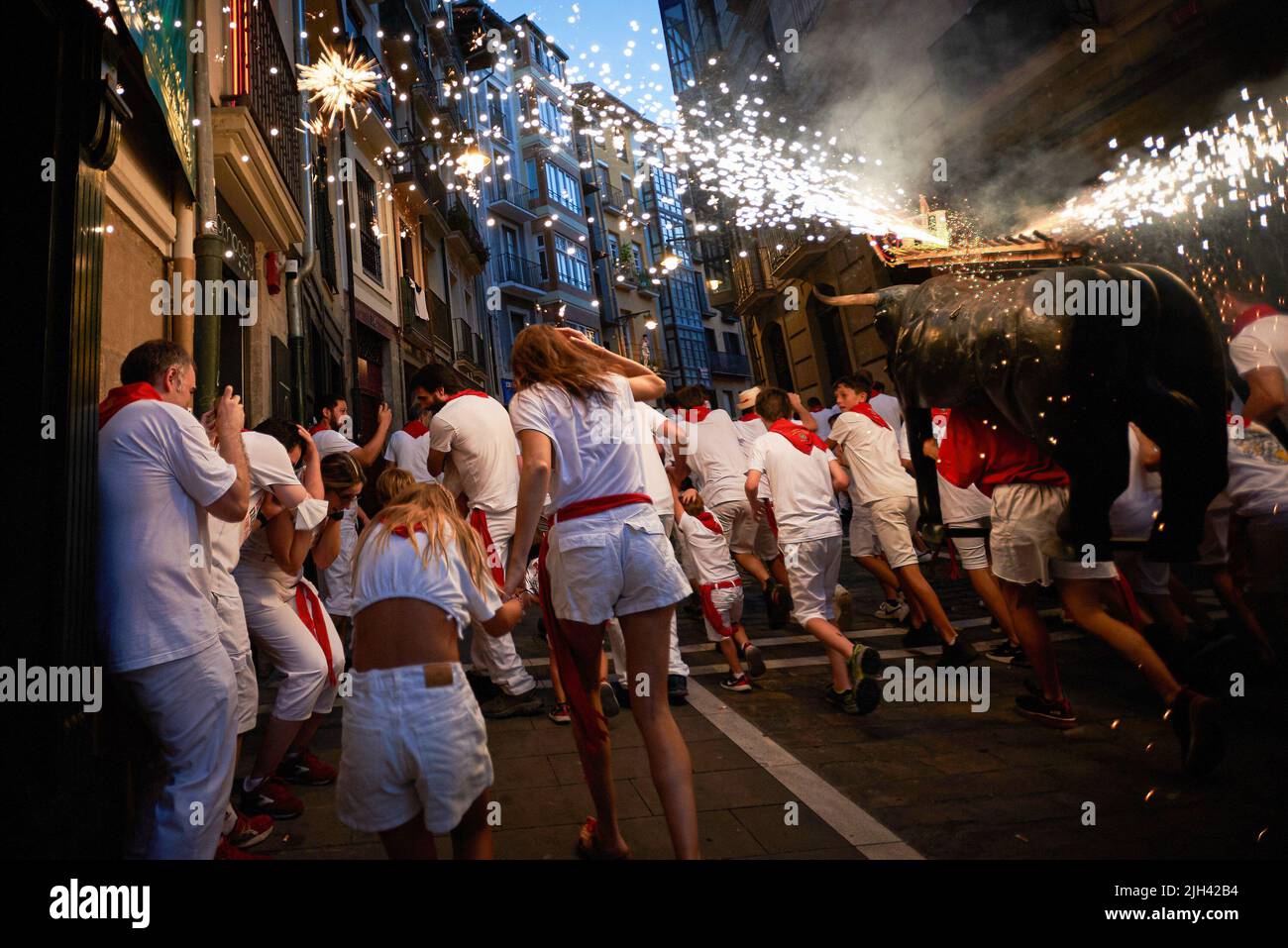 Pamplona, Spagna. 14th luglio 2022. La gente corre dietro il toro del fuoco durante le festività di San Fermín. Un uomo che porta una struttura a forma di toro carica di fuochi d'artificio chiamati Toro de Fuego (toro del fuoco), spara fuoco e corre per le strade della città vecchia di Pamplona durante le festività di San Fermín. (Foto di Elsa A Bravo/SOPA Images/Sipa USA) Credit: Sipa USA/Alamy Live News Foto Stock