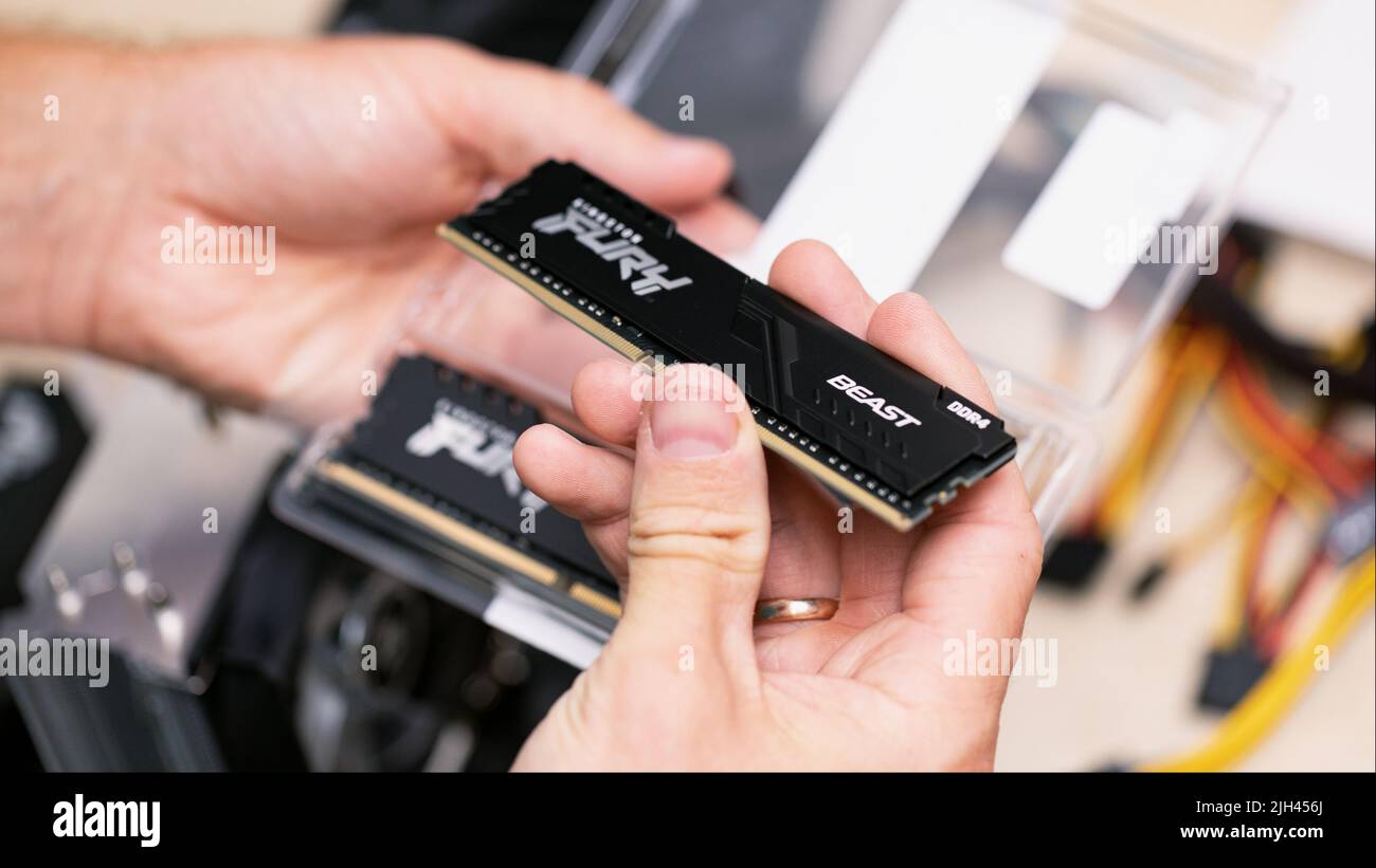 Uomo che tiene computer Furry Beast RAM DDR4 stick su scheda madre di computer professionale per la criptovaluta mineraria. Russia, 17.08.2021 Foto Stock