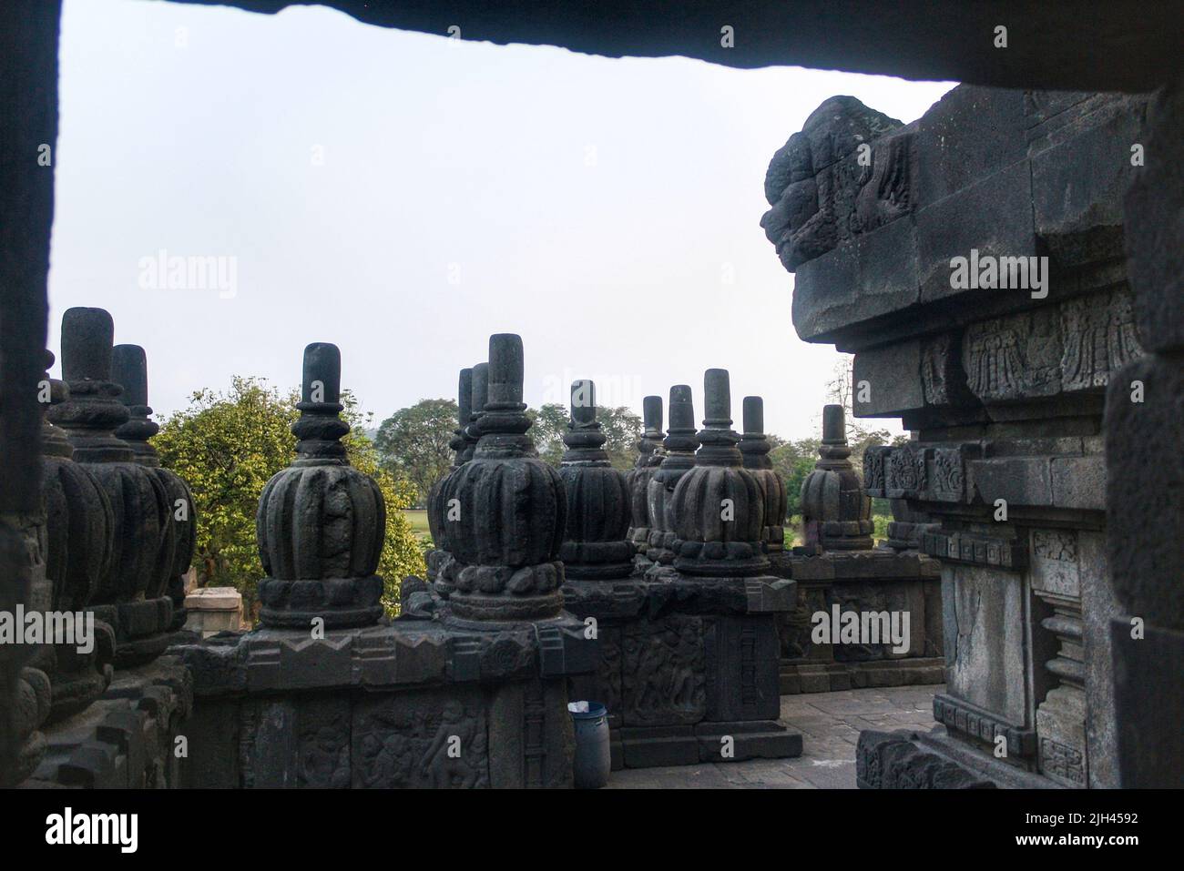 Interno di un tempio nell'antico complesso del tempio Prambanan. Vista di corridoio vuoto stretto con rilievi sulla parete. Nessuna gente. Foto Stock