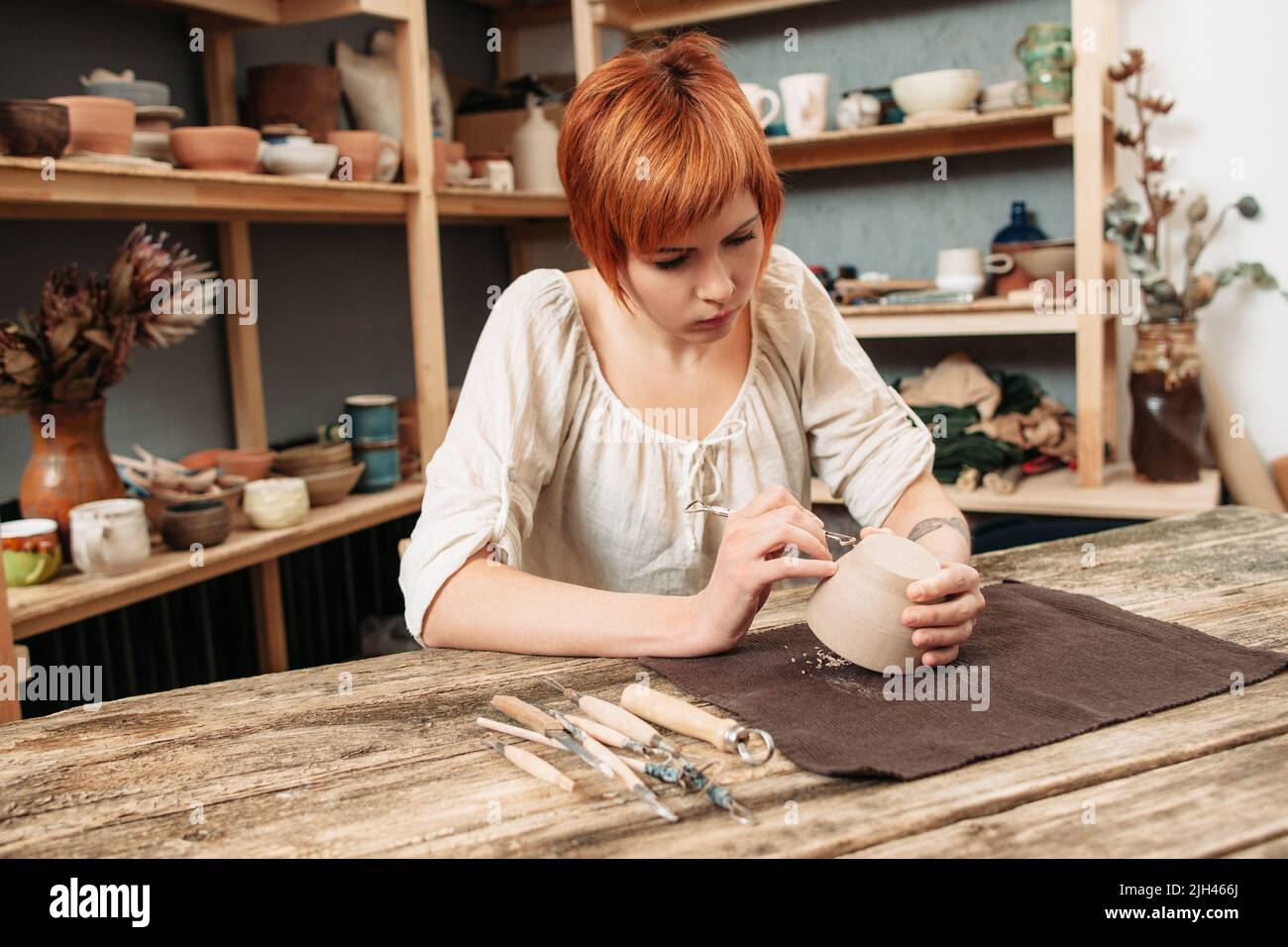 Femmina potter completare la sua creazione in studio Foto Stock