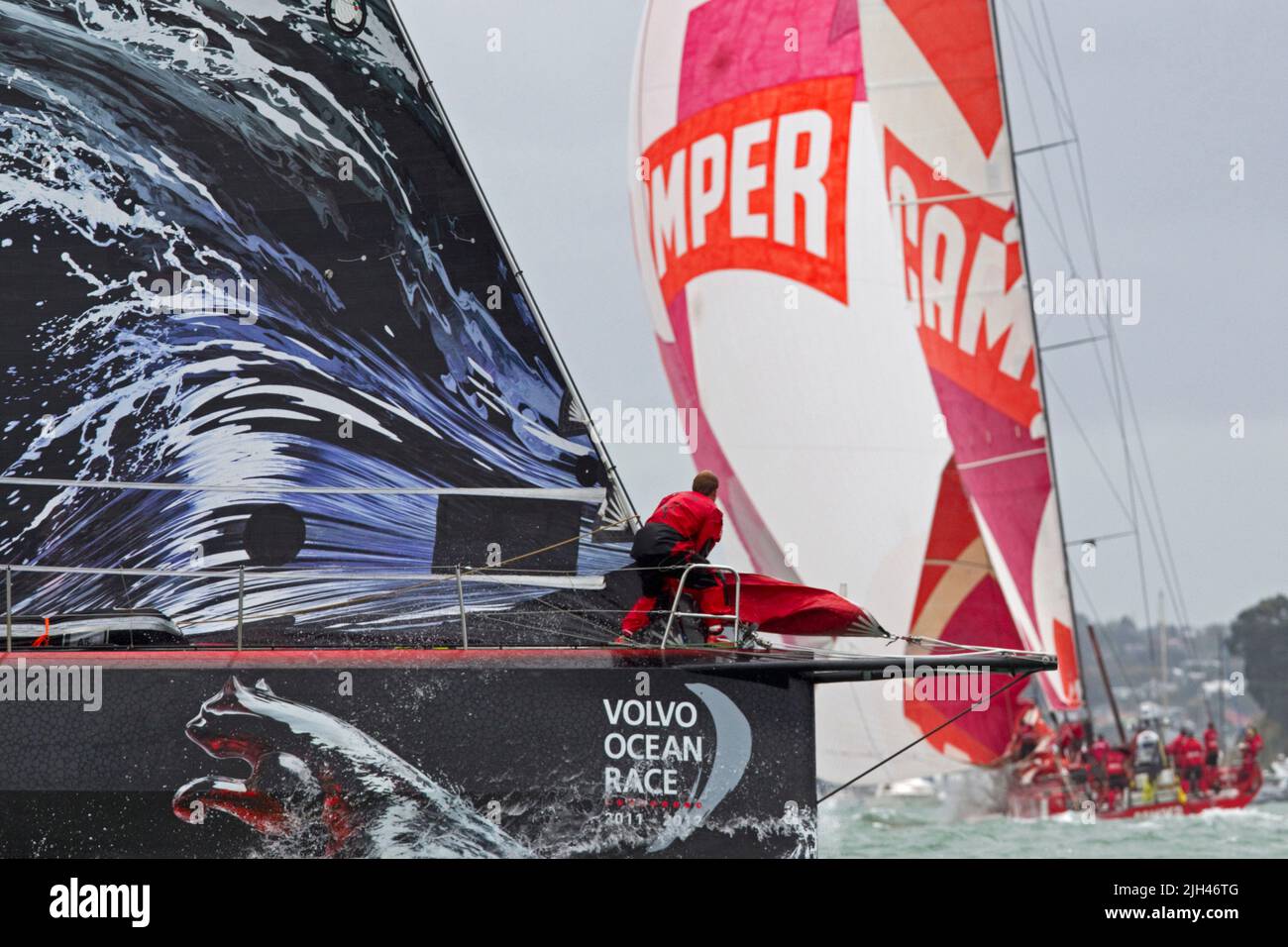 Puma Ocean Racing bowman Casey Smith guarda mentre inseguono Camper con Emirates Team New Zealand che gareggia nella corsa in porto Foto Stock