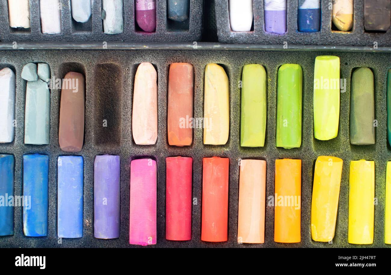 Morbido arcobaleno colorato gesso pastello per disegnare. I pastelli dell'artista multicolore nella scatola. Foto Stock
